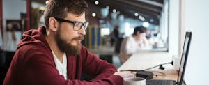 Man looking at a computer to learn about everything you need to know about the new VantageScore 4.0 credit scoring model