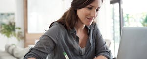 Woman using her laptop to learn how to get out credit card debt