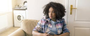 Concerned-looking young woman wondering how long late payments stay on a credit report