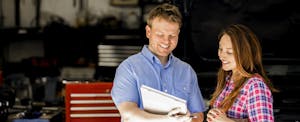 Woman talking to a mechanic about her recalled car Woman talking to a mechanic about her recalled car