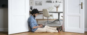 A man sitting on the floor of his living room discovers how refinancing a mortgage works