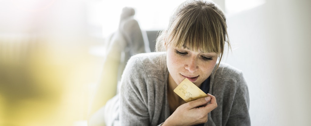 Woman lying on couch with credit card and tablet