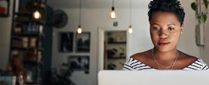 Shot of a young woman using a laptop in a cafe