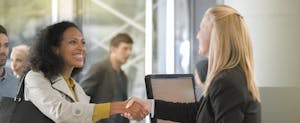 Woman shaking hands with female customer