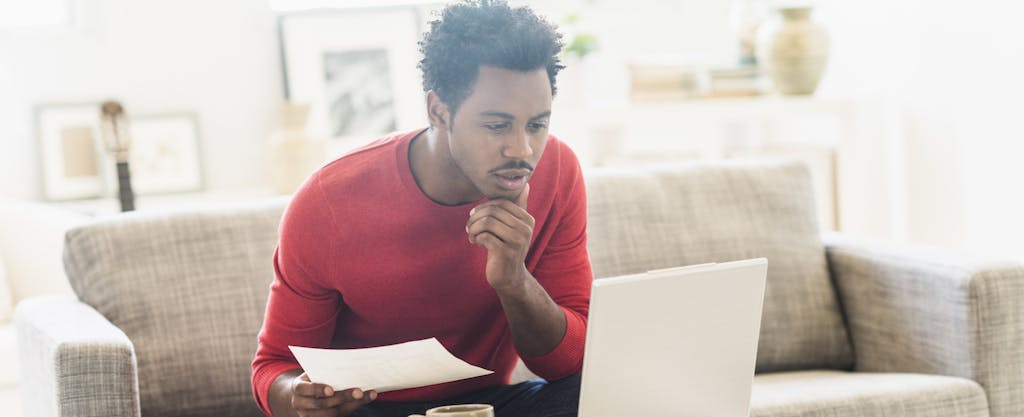 Man sitting on sofa and using laptop