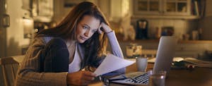 Concerned woman looks at her computer.
