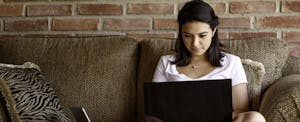 young woman working on a laptop computer at home.
