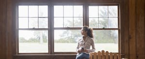 Young woman with phone in rustic lodge