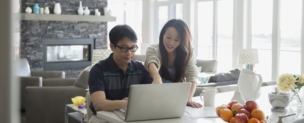 Father and daughter at laptop in kitchen