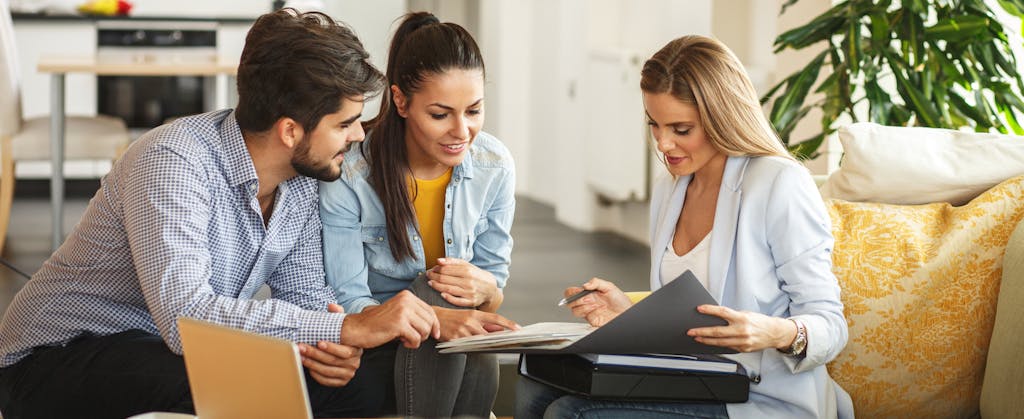 Female Real Estate agent offers insurance to young couple.