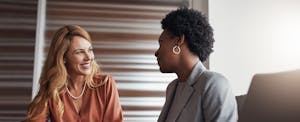 Two women sitting at a table and having a meeting