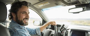 buying-car-out-of-state Man driving a car and smiling