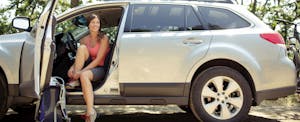 car-loan-amortization Smiling woman sitting in car getting ready to go on a hike