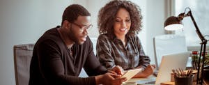 prequalify-auto-loan_670549718 Young couple sitting at home office desk trying to see if they can prequalify for an auto loan