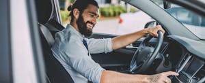 residual-value-determined_1018728620 Young man in car adjusting radio