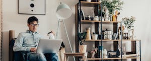 Man sitting at home in his living room, working on his laptop