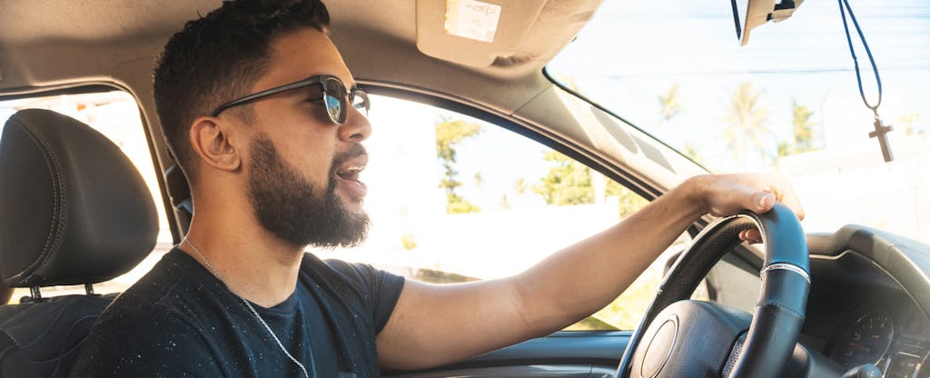 Man driving a car and singing