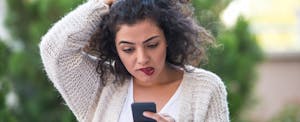 una mujer mira preocupada su teléfono