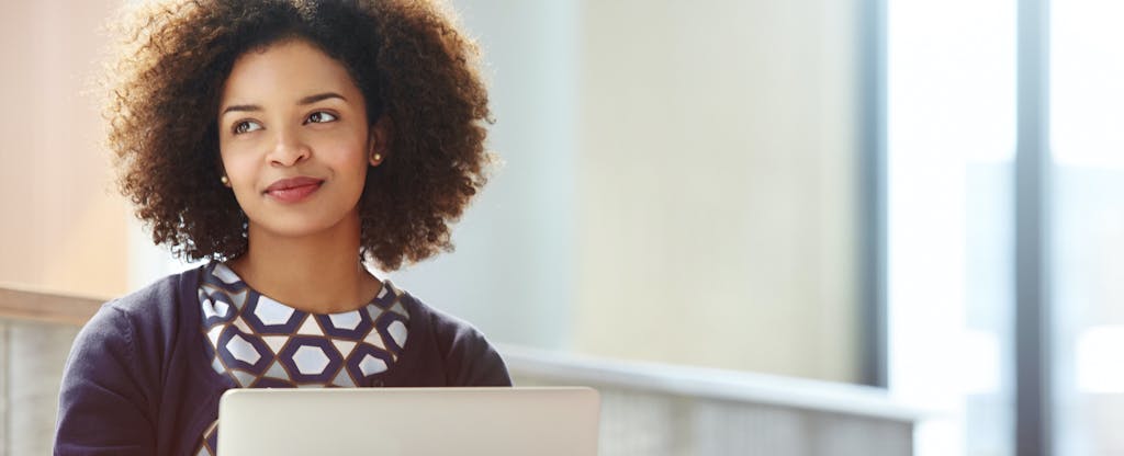 Woman sitting at computer thinking about taking out a loan