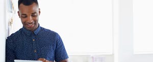 Man smiling and reading on his phone about what a fair credit score is
