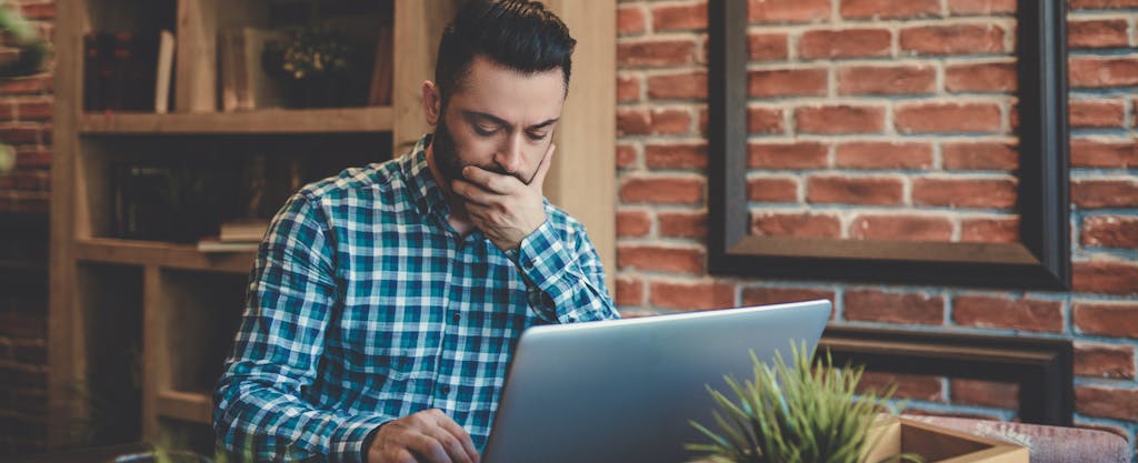 Contemplative man looks up tax implications of IRA conversion to Roth