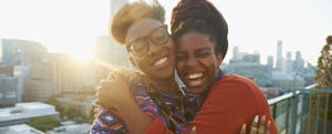 Women hugging on city rooftop