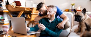 Couple at home sitting together in their living room, shopping online with their Citi card