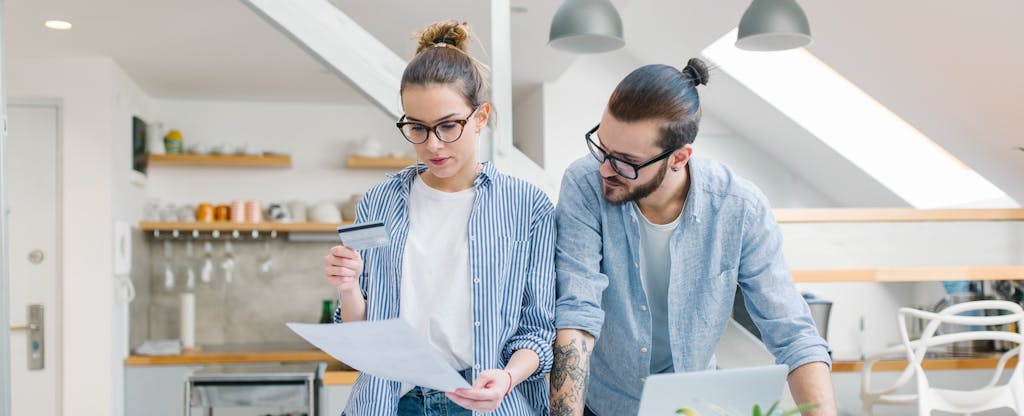 Young couple paying bills with a credit card