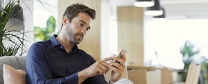 crypto-loans Man using his phone in the office