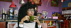 Woman looking thoughtful while drinking coffee in a cafe