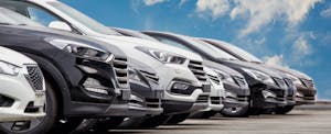 electric-auto-insurance-review A row of cars under a blue sky.