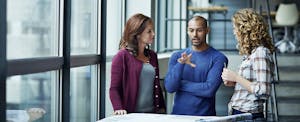 Three coworkers discuss business plans.